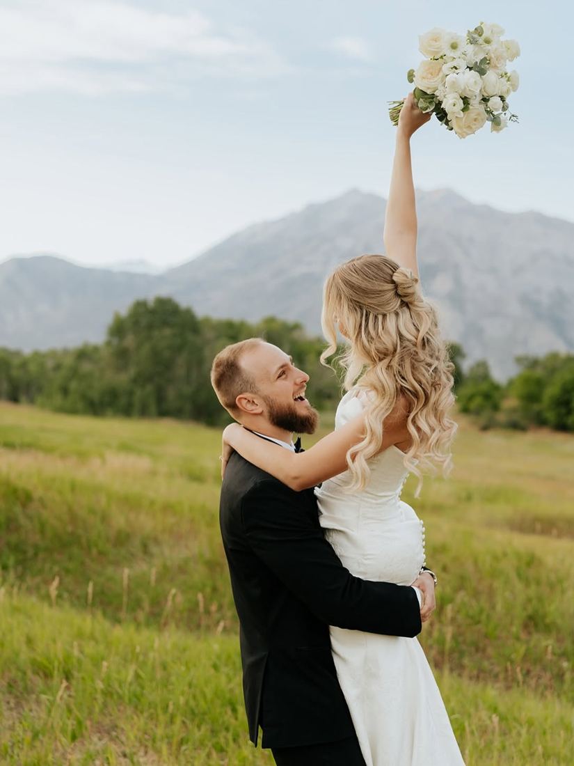 Bride with half-up bun and long blonde curls in a Utah mountain meadow